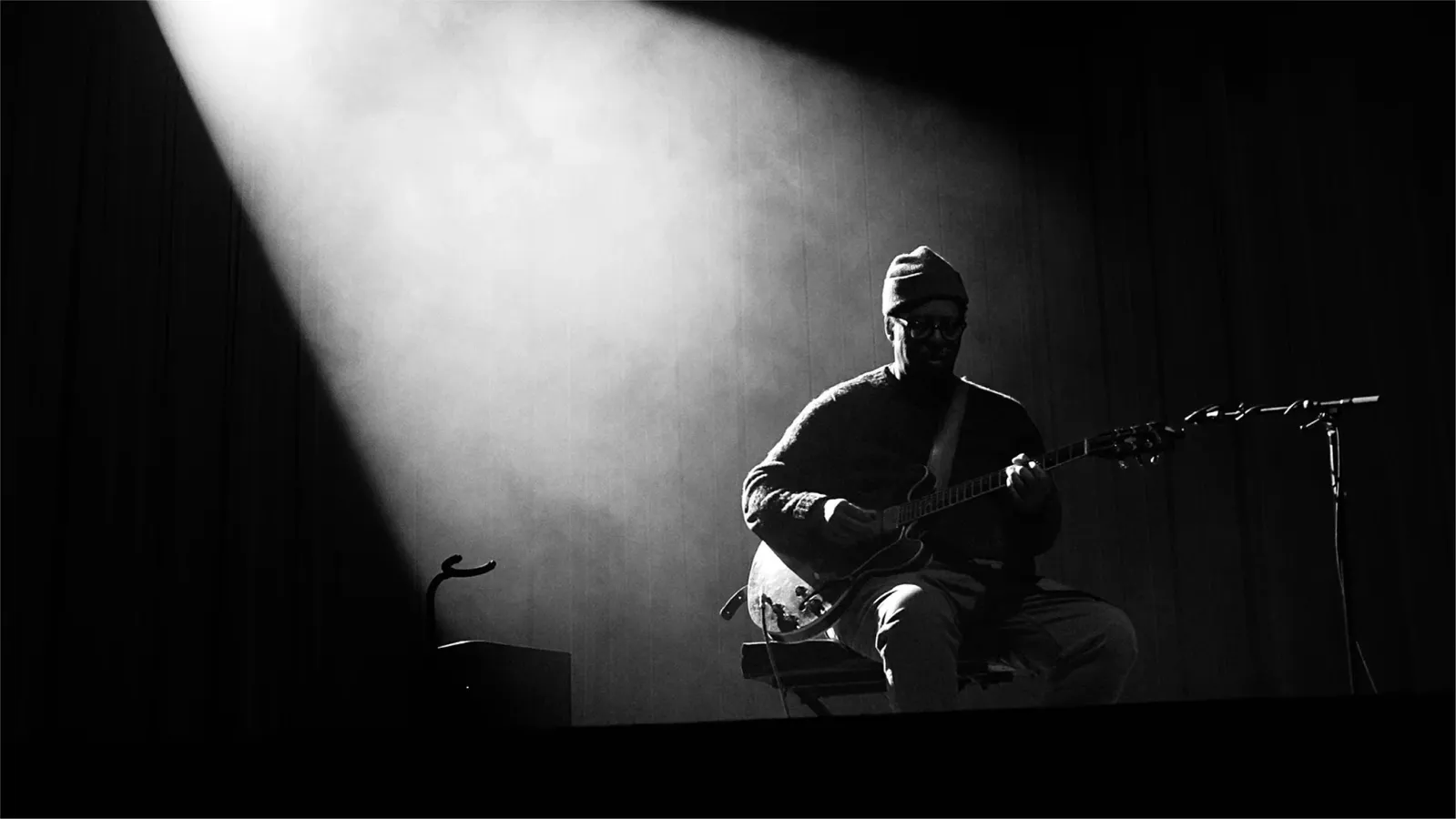 Jeff Parker on a dark stage in the beam of a stage light